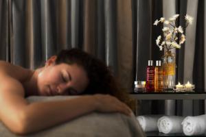 a woman sleeping on a couch with her head on a pillow at Le Pinarello in Sainte-Lucie de Porto-Vecchio