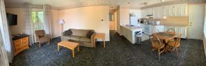 a living room with a couch and a table and a kitchen at Marine Village Resort in Lake George