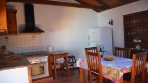Una cocina con una mesa y un refrigerador blanco. en Casita del Pedregal, en Valle Gran Rey