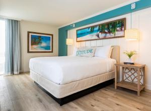 a bedroom with a large white bed and a table at Margaritaville Lake Resort, Lake Conroe in Montgomery