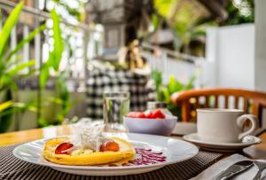 a table with a plate of food on a table at Askara Guest House & Hostel in Ubud