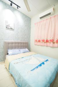 a bedroom with a bed with a blue comforter at Homestay UTM JPO SKUDAI Pulai Jaya Kangkar Pulai Near Taman Universiti in Kampung Kangkar Pulai