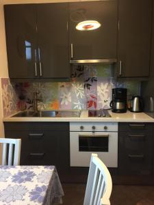 a kitchen with black cabinets and a stove and a table at Trento Small View in Trento