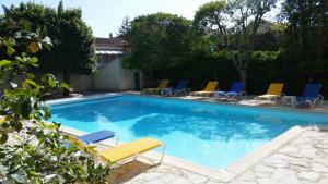 een zwembad met blauwe en gele ligstoelen bij Paradix holiday apartment - gîte 1, 4 pers in Nissan-lez-Enserune