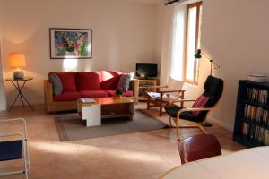 een woonkamer met een rode bank en stoelen bij Paradix holiday apartment - gîte 1, 4 pers in Nissan-lez-Enserune