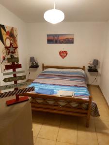 ein Schlafzimmer mit einem Bett mit einem Herz an der Wand in der Unterkunft Airport View House in Artemida