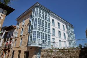 a tall white building with windows on the side of it at Hondarribia Suites in Hondarribia
