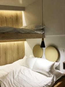 a bedroom with two bunk beds and a white bed at The Goose House Ubon in Ban Na Khwai +6 photos