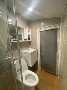 a small bathroom with a toilet and a shower at The Goose House Ubon in Ban Na Khwai