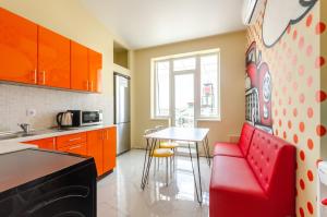 a kitchen with a red couch and a table at Guest House WOW in Kyiv