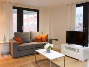 a living room with a couch and a tv at Central Tower Bridge Apartment in London