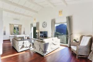a living room with white furniture and a large window at Villa Maona - con piscina tra Firenze e Pisa in Montecatini Terme