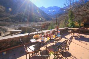 d'une table et de chaises sur un balcon avec vue sur la montagne. dans l'établissement Hotel Aremd - Aroumd Imlil route du Toubkal, à Imlil