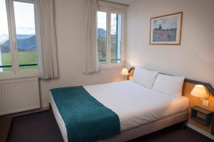Un pat sau paturi într-o cameră la Hotel Les Mésanges