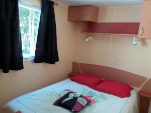 ChasseradèsLe SOUS BOIS DE JADE CHEMIN DE STEVENSON GR 70的小卧室配有带2个红色枕头的床