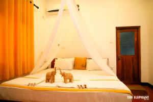 um quarto com uma cama com dois elefantes em The Elephant Next-Door em Udawalawe