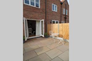 a patio with a fence and a table and chairs at Raynolds Cottage Blidworth in Blidworth