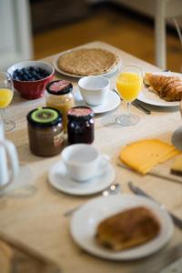 stół z talerzami jedzenia i szklanki soku pomarańczowego w obiekcie B&B La Ferme de l'Airbois w mieście Yvoir
