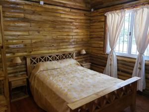 a bedroom with a bed in a log cabin at Cabaña El Refugio in Open Door +34 photos