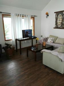 a living room with a couch and a table at Cabañas y Deptos Cuatro Estaciones in Frutillar