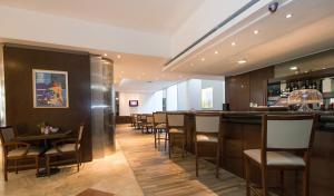 a bar in a restaurant with tables and chairs at Urquiza Apart Hotel & Suites in Rosario +46 photos