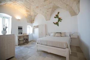 a bedroom with a bed and a desk in a room at Radici Ostuni in Ostuni