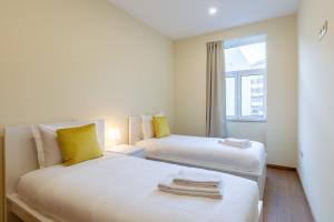 2 camas en una habitación pequeña con ventana en Yellow Tiles by PCALE, en Oporto