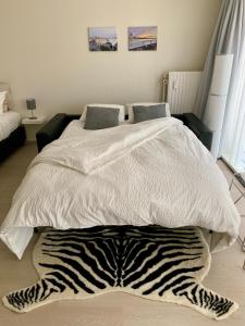 a bedroom with a bed with a zebra rug on the floor at Studio De Strandsuite in Ostend