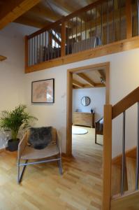 ein Wohnzimmer mit einer Treppe und einem Stuhl in der Unterkunft Waterfall View Luxury Penthouse in Lauterbrunnen