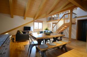 ein Wohnzimmer mit einem Holztisch und einer Holztreppe in der Unterkunft Waterfall View Luxury Penthouse in Lauterbrunnen