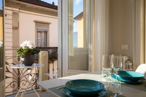een tafel met blauwe borden en glazen op een balkon bij Aqualago casa vacanze apartment D in Verbania