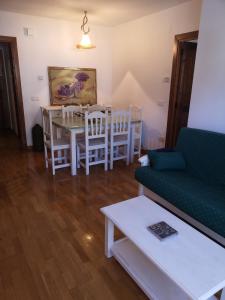 a living room with a couch and a table and chairs at Residencial Valle de Benasque in Benasque
