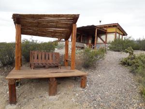 a wooden bench sitting in front of a building at Cabaña La Mostacita - Complejo El Taller in Potrerillos