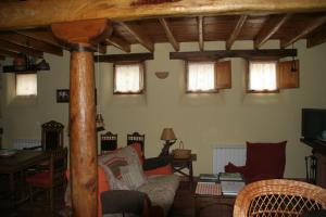 a living room with chairs and a table and windows at El Canto del Gallo in Ranedo de Curueño