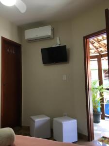 een woonkamer met airconditioning aan de muur bij Varandas do Atalaia Suítes in Arraial do Cabo