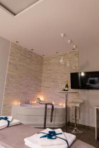 a bathroom with a tub and a table with chairs at SPA Apartment Nalis in Niš
