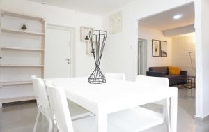 a white dining room with a white table and chairs at "הפינה שלי בטבריה" in Tiberias