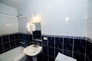 a bathroom with a sink and a toilet and a tub at Hotel Peru Real in Cusco