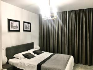 a bedroom with a large bed and a chandelier at Modern 3-bedroom jacuzzi apartment in Lviv