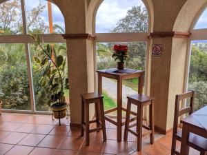 a room with a table with a vase of flowers on it at Hostal La Dehesa in Villanueva del Rey +48 photos