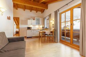 a kitchen and living room with a table and a couch at Gästehaus Bergwinkl in Reit im Winkl