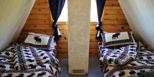 Habitación con 2 camas y almohadas. en Yellow Dog Lodge, Inc., en Yellowknife