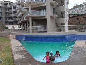 three children in a swimming pool in a building at Whale Rock in Margate