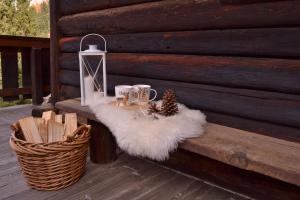 una panchina di legno con un tappeto bianco e un cesto di Baita Toè a Canazei