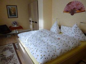 um quarto com uma cama com um edredão branco em Haus Pia em Oberhof