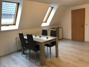a dining room with a table and black chairs at Ferienwohnung Hendrich Sotterhausen in Allstedt