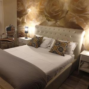 una camera da letto con un grande letto con una parete fiorita di Rigoletto Rental Rooms a Verona