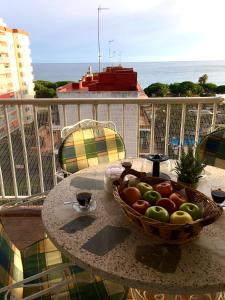 un bol de fruta sentado en una mesa en un balcón en Sunshine apartment with great sea view and terrace in Malgrat de Mar, en Malgrat de Mar