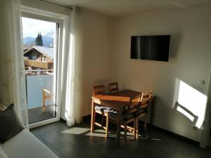 a dining room with a table and a television on the wall at Apartment Peotta in Volders