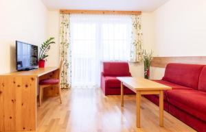 ハウス・イム・エンスタールにあるLandhaus Birgitのリビングルーム(赤いソファ、テレビ付)